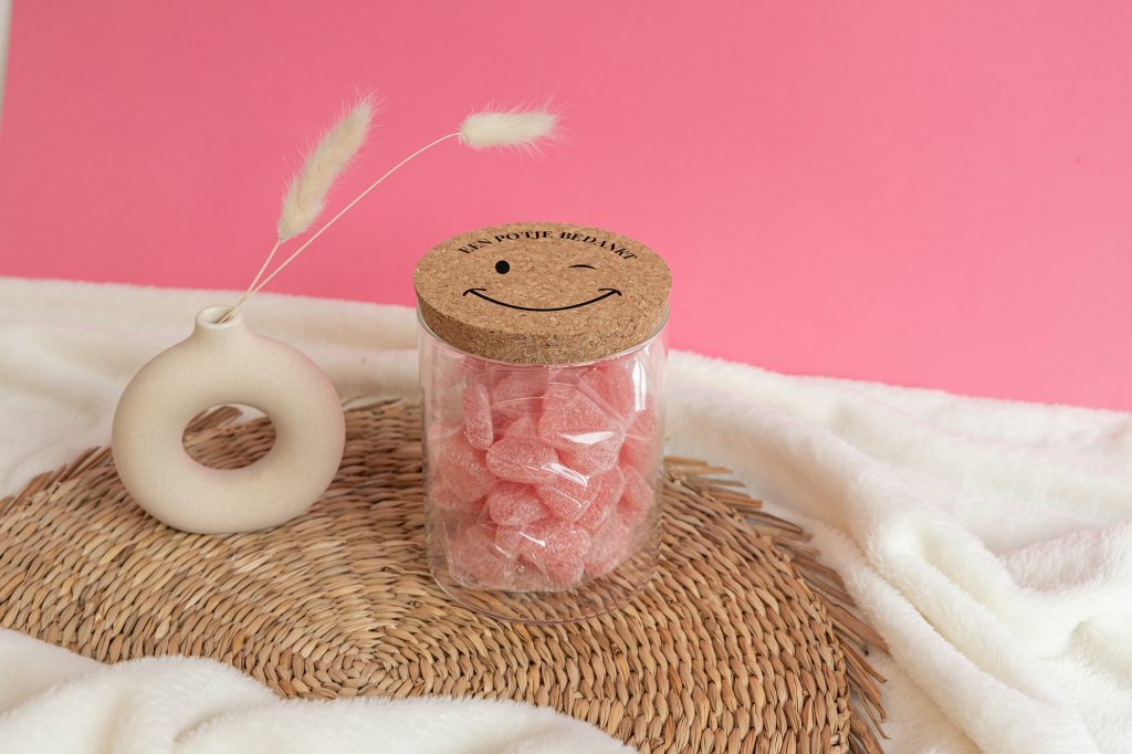 Snoeppot met gepersonaliseerd deksel met eigen tekst. De voorbeeldtekst luidt "Een potje bedankt" met daaronder een lachebekje