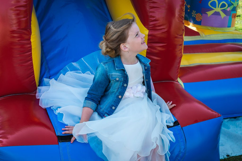 Communicantje met wit kleedje op een springkasteel.