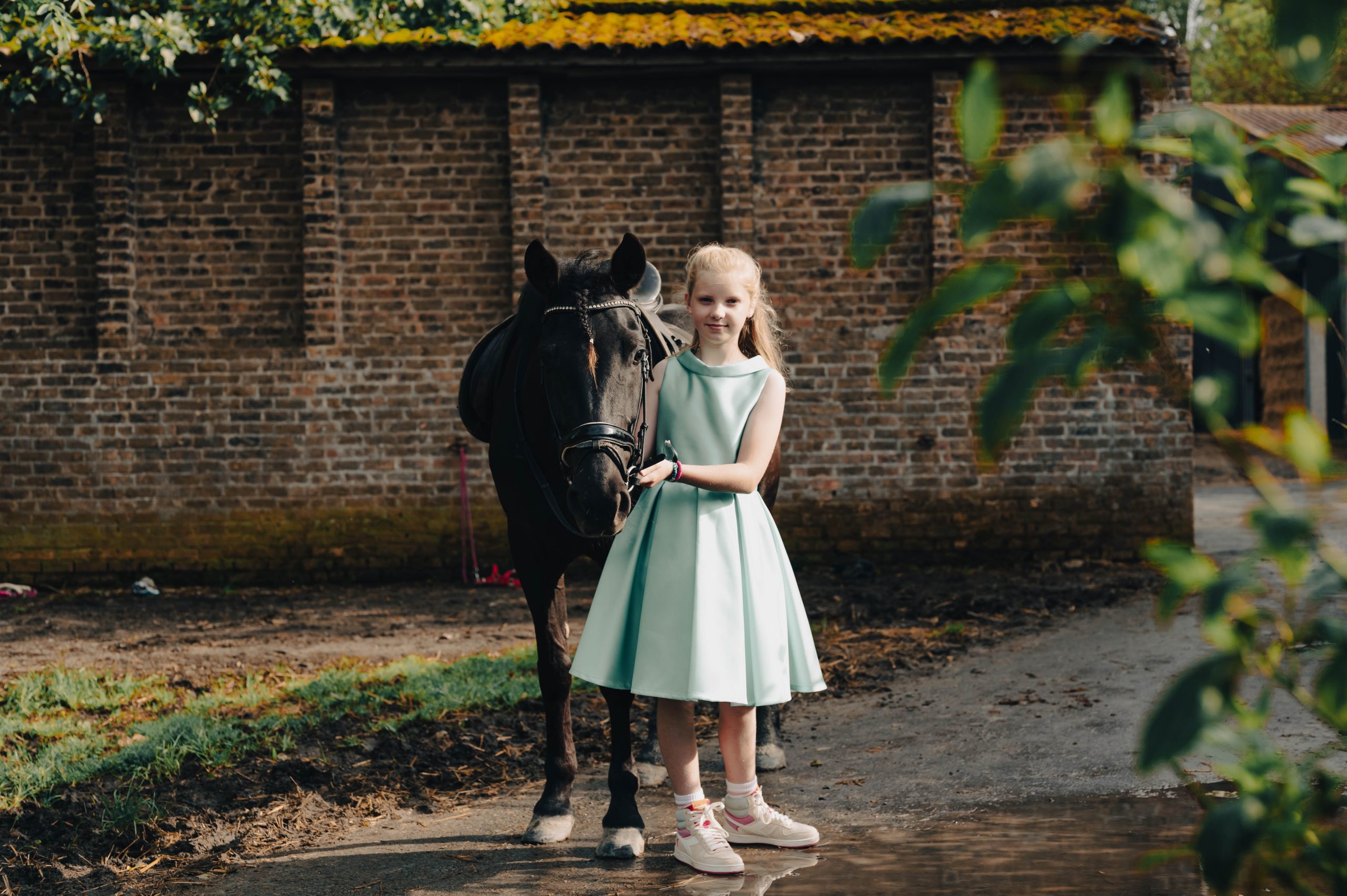 Schattige communiefoto van meisje in blauw kleedje met pony