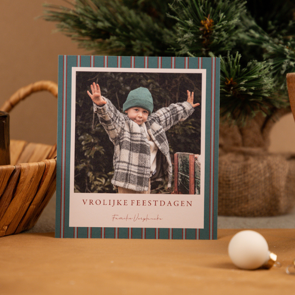 Kerstkaart met foto en gestreepte achtergrond met groene en rode kleuren.