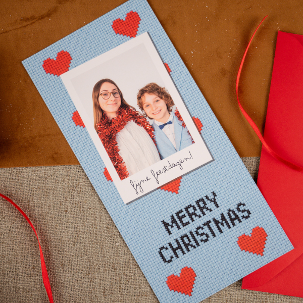Hippe kerstkaart in kruissteekmotief met blauwe achtergrond, hartjes en foto